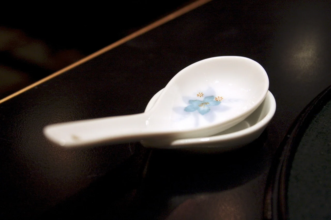 An empty white soup spoon on its rest.